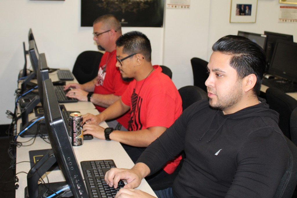 Veterans Dante Tapia Garcia (front), Arthur Matedne (center), and 
Jeremy Caylor research GI Bill benefits at Delta College.