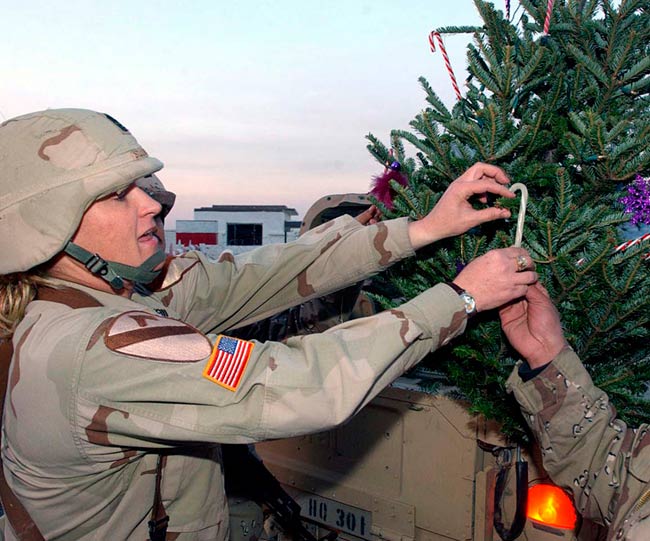 Army Pfc. Erika Bruner, of Headquarters Company, 4th Brigade Combat Team, 1st Cavalry Division, places the traditional topper on a real, Douglas fir Christmas tree.
Photo by Cpl. Benjamin Cossel, USA