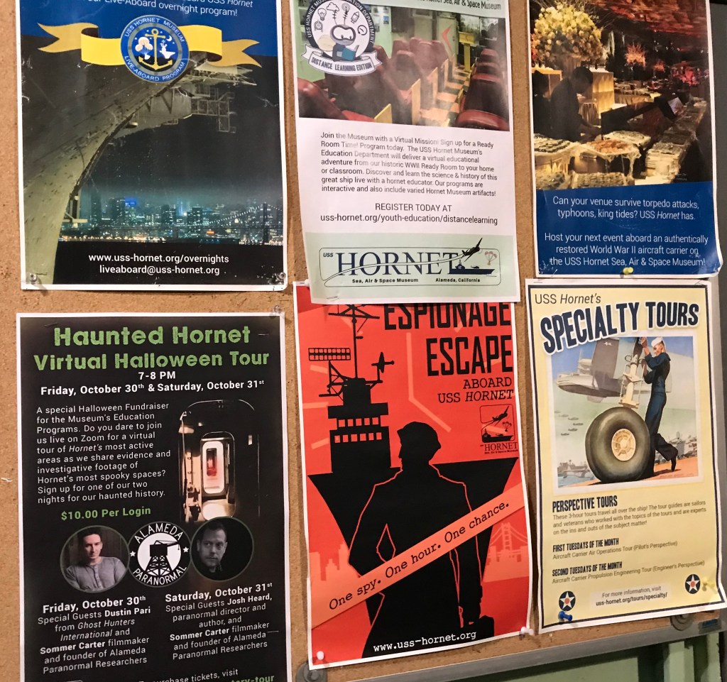 A picture of event flyers hanging on the entrance door to the USS Hornet.