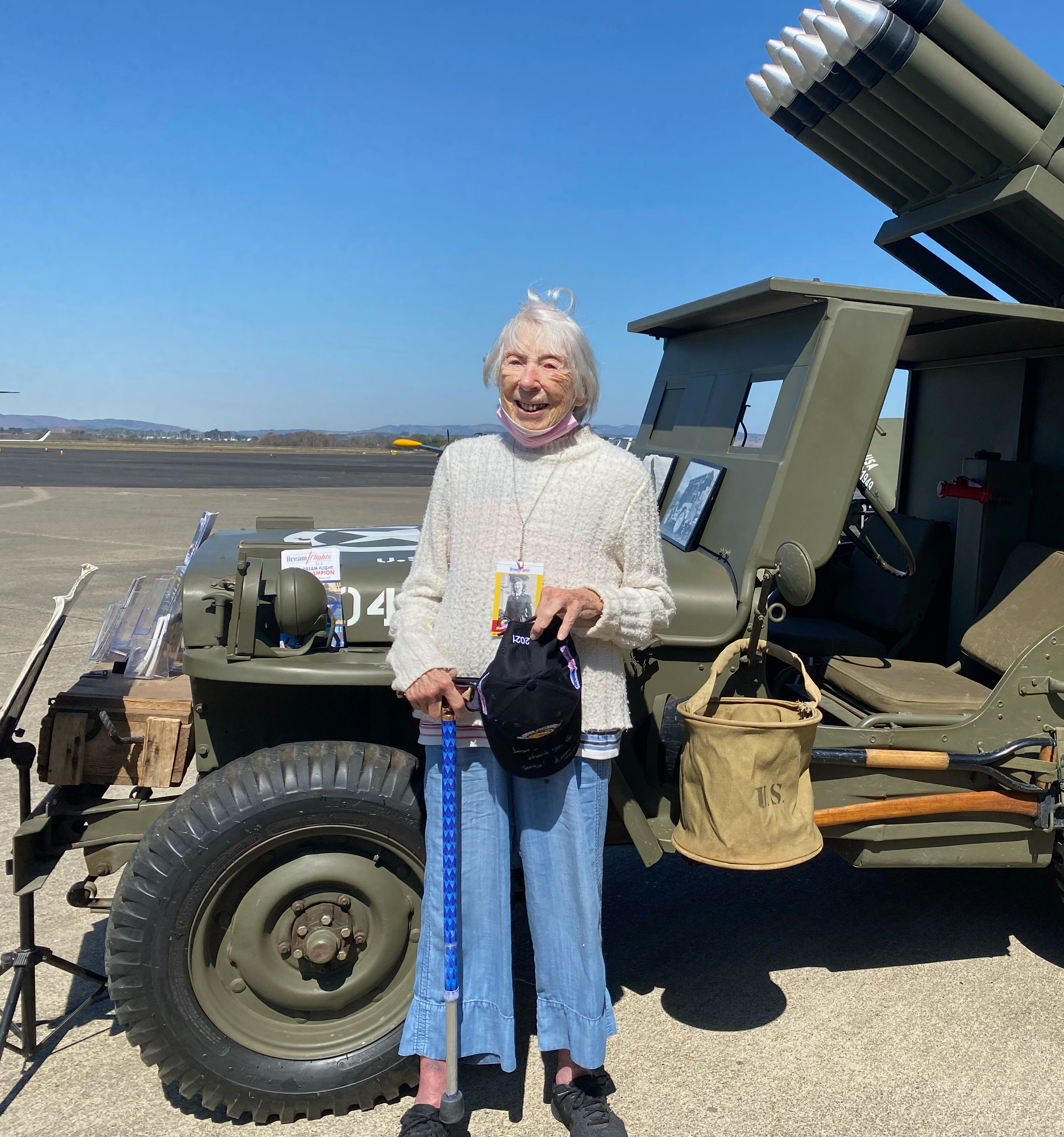 US Navy WAVE Janet Mull stands next to an old Army Jeep.