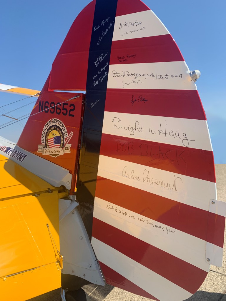 A picture of the tail of the plane with an autograph signature from each of the days passengers.