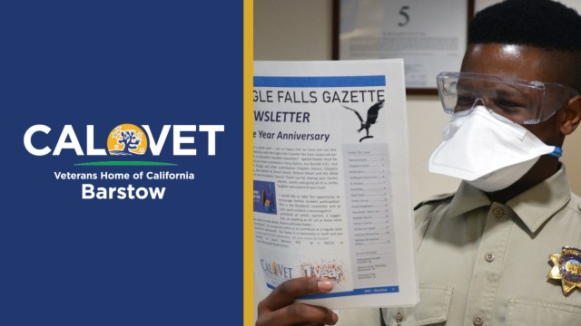 Security officer at the front desk of the Veterans Home reads a copy of the Eagle Falls Gazette.