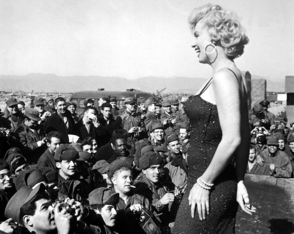 A photo of Marilyn Monroe on tour with the USO entertaining the troops.