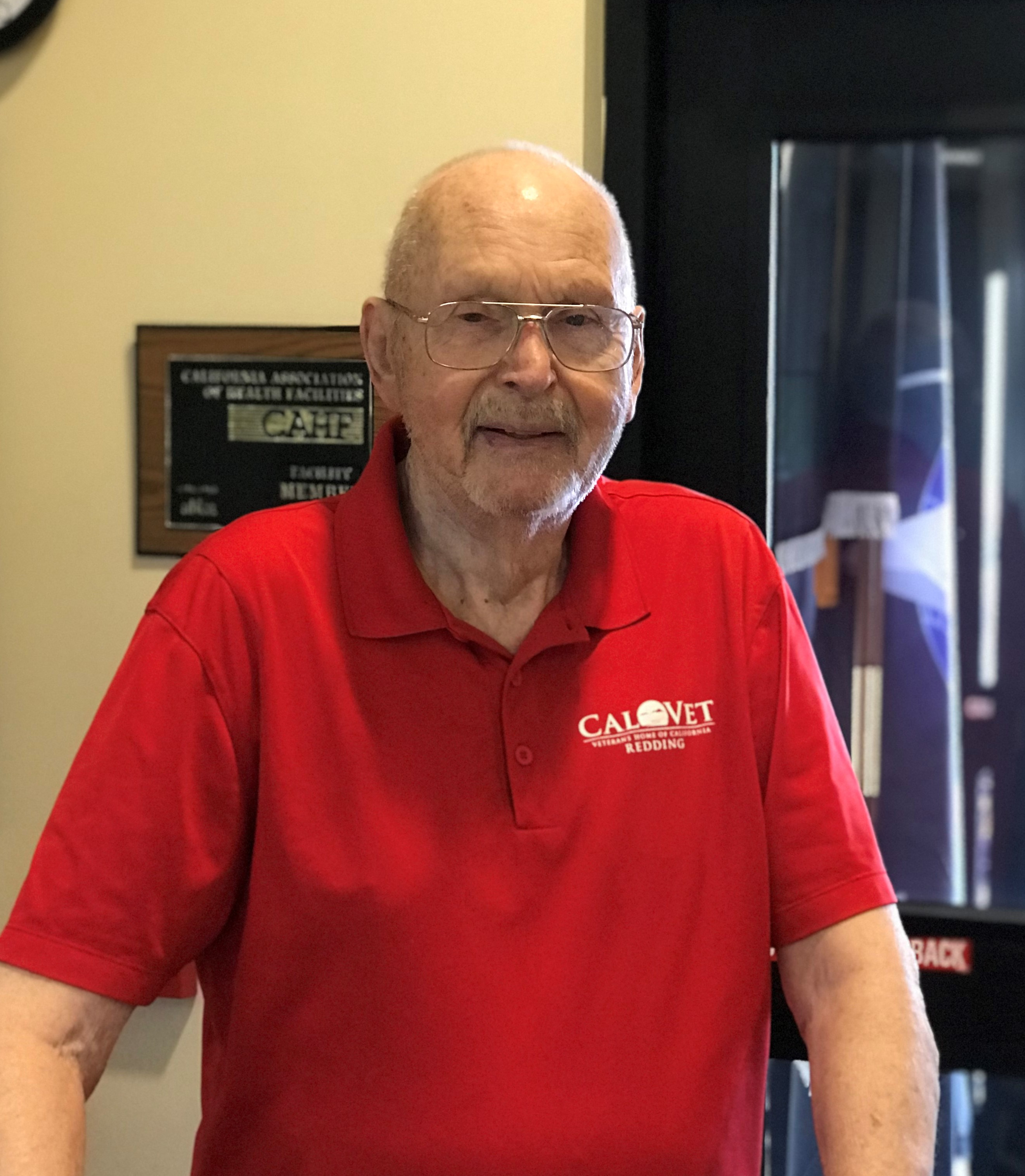 Bob Lewis dressed in red polo shirt with white Redding Home logo on shirt.