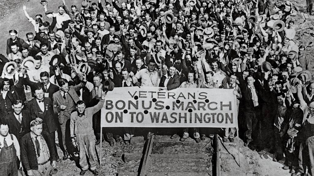 Black and white group shot of many veterans marching onto Washington.