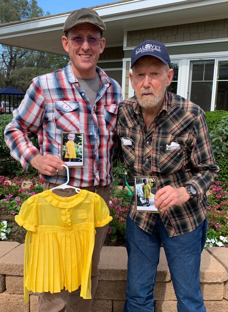 Dallas Carlon, and his father, Harold Carlon, a resident at the Veterans Homes of California-Redding, display the yellow dress made from a parachute brought home by Dallas’ great uncles from a Japanese POW camp when World War II ended.