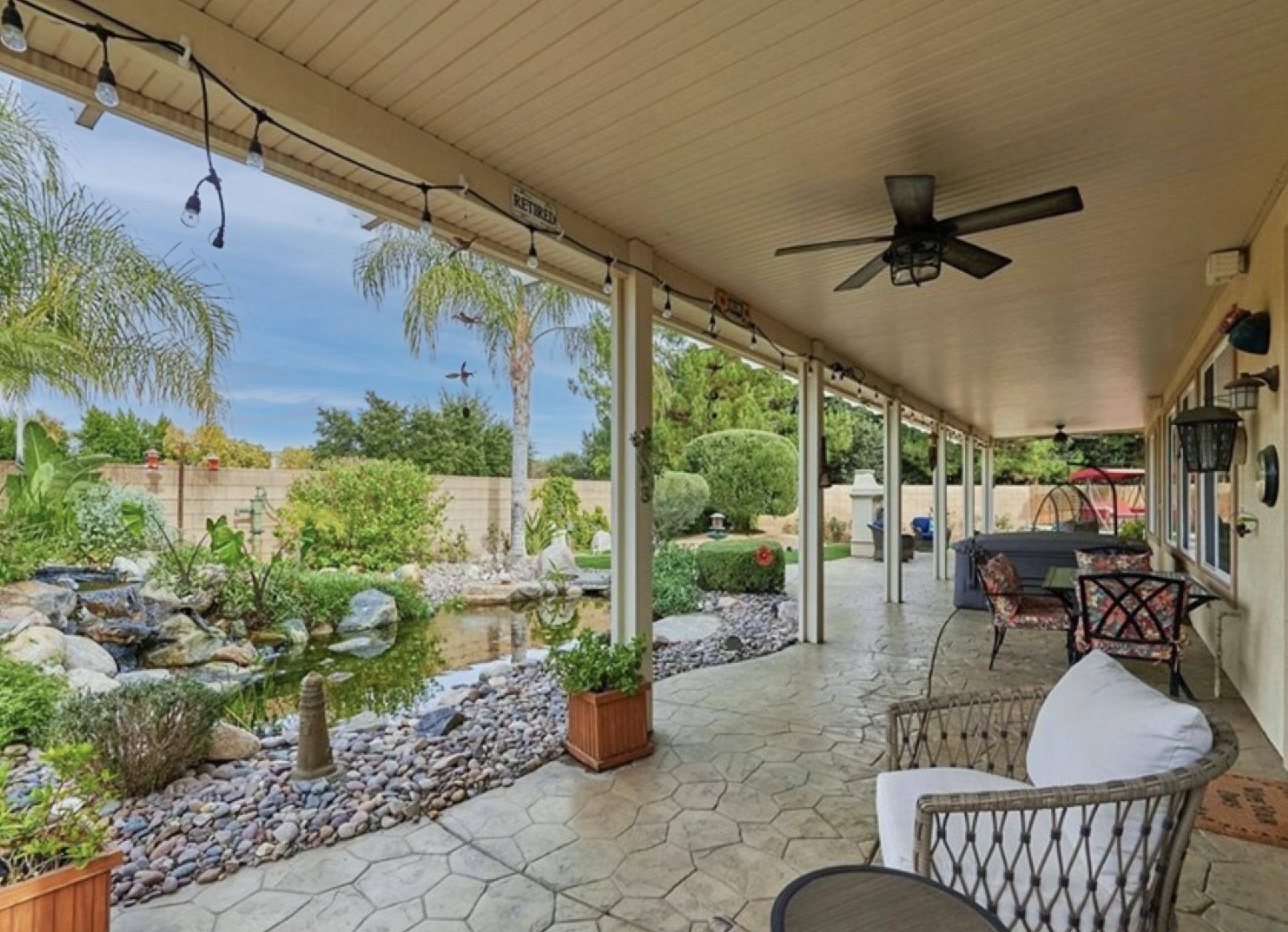 A look at the backyard including a koi pond and covered porch.