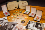 Military medals and badges, plus photographs.
