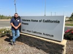 Man standing near sign reading "Veterans Home of Fresno, 2811 West California Avenue.