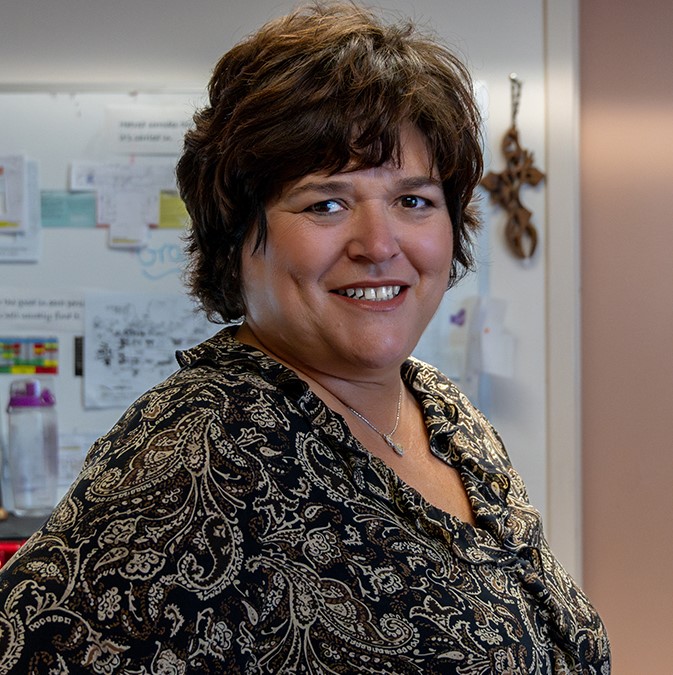 Woman smiling in indoor setting.