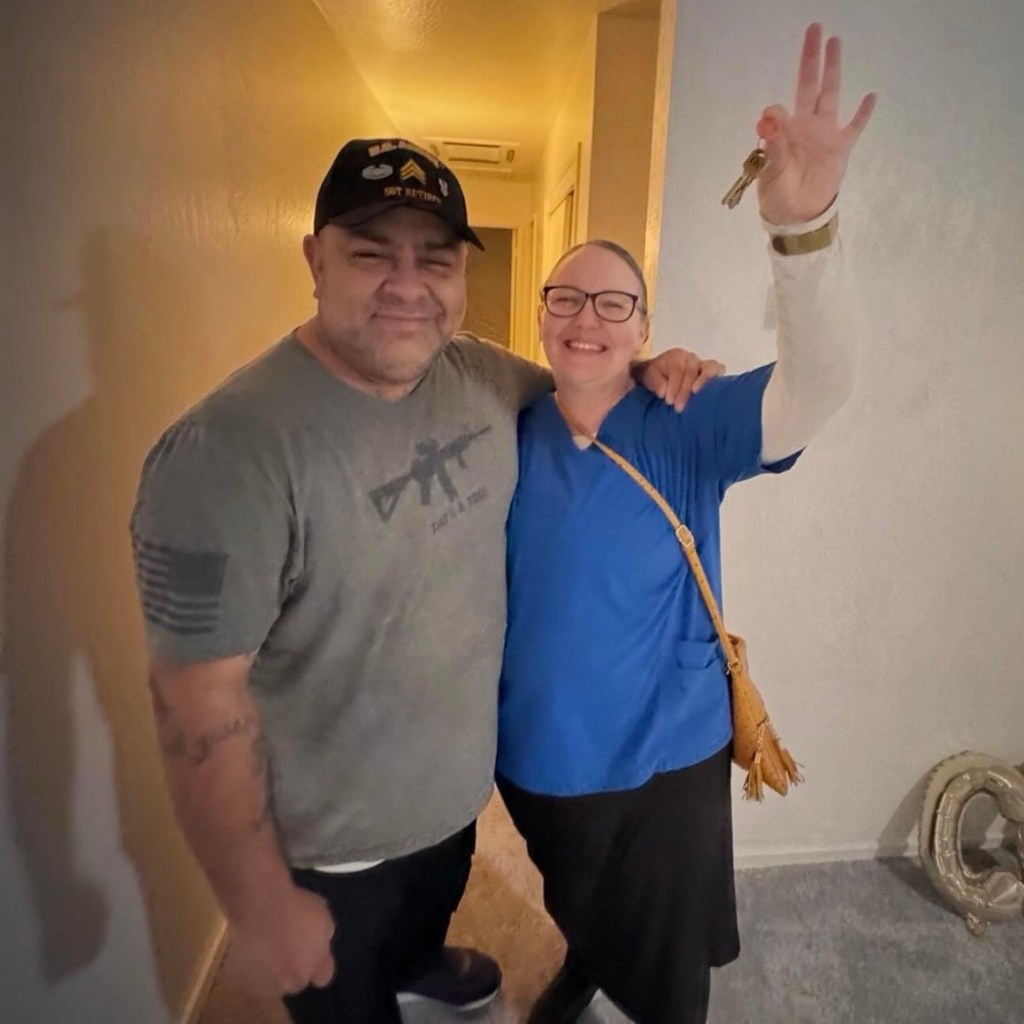Man and woman inside house, with woman holding up keys.